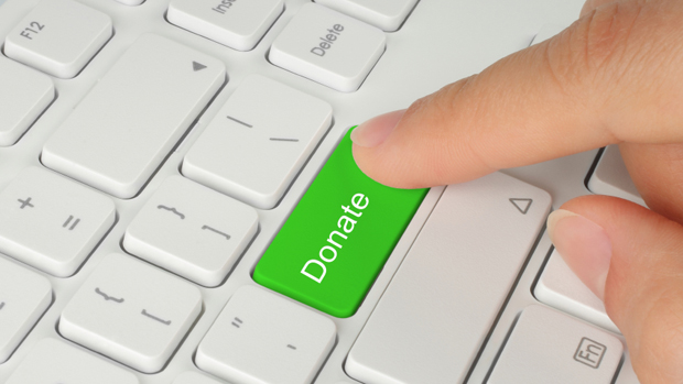Hand pushing green donate button