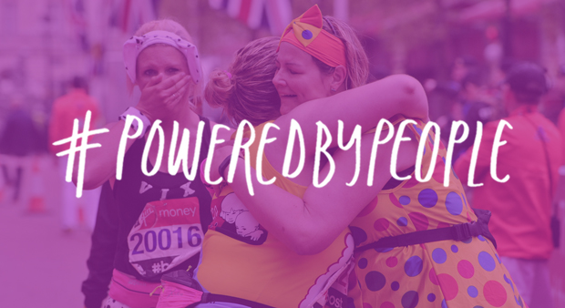 Two runners hugging after crossing the London Marathon finish line with the #PoweredByPeople logo overlaying