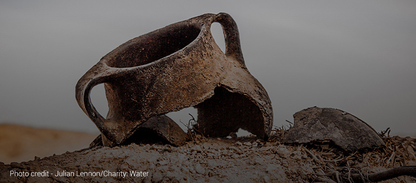 A broken clay jug in the sand.