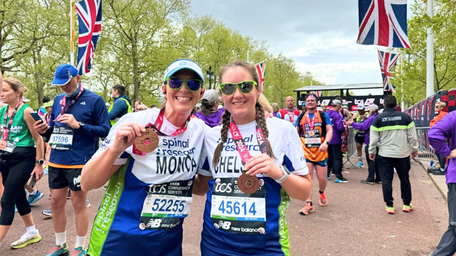 Foto mostrando dois arrecadadores de fundos da Spinal Research segurando suas medalhas após completarem a Maratona de Londres.