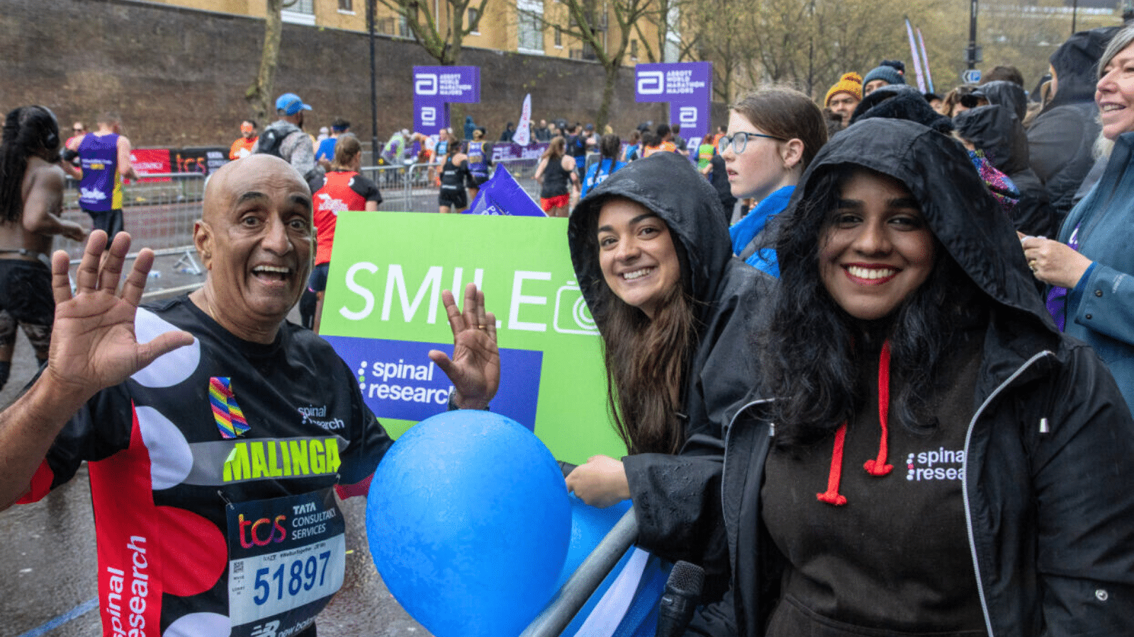 Foto mostrando membros da equipe Spinal Research torcendo por um participante da Maratona de Londres na Maratona de Londres.