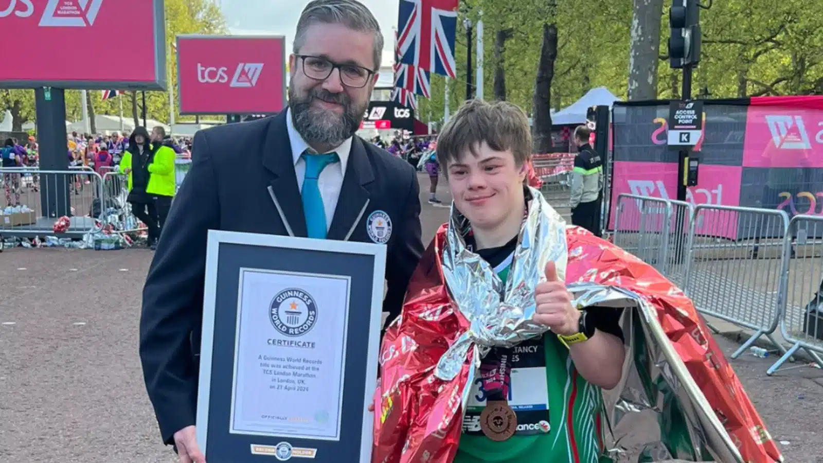 Photo showing Lloyd Martin posing with a Guinness World Records representative following his completion of the London marathon.