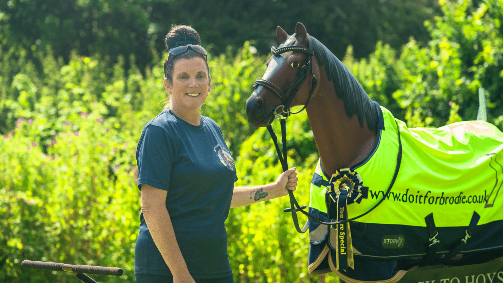 Image showing JustGiving Award winner Emma Webb posing next to her 80kg horse statue.