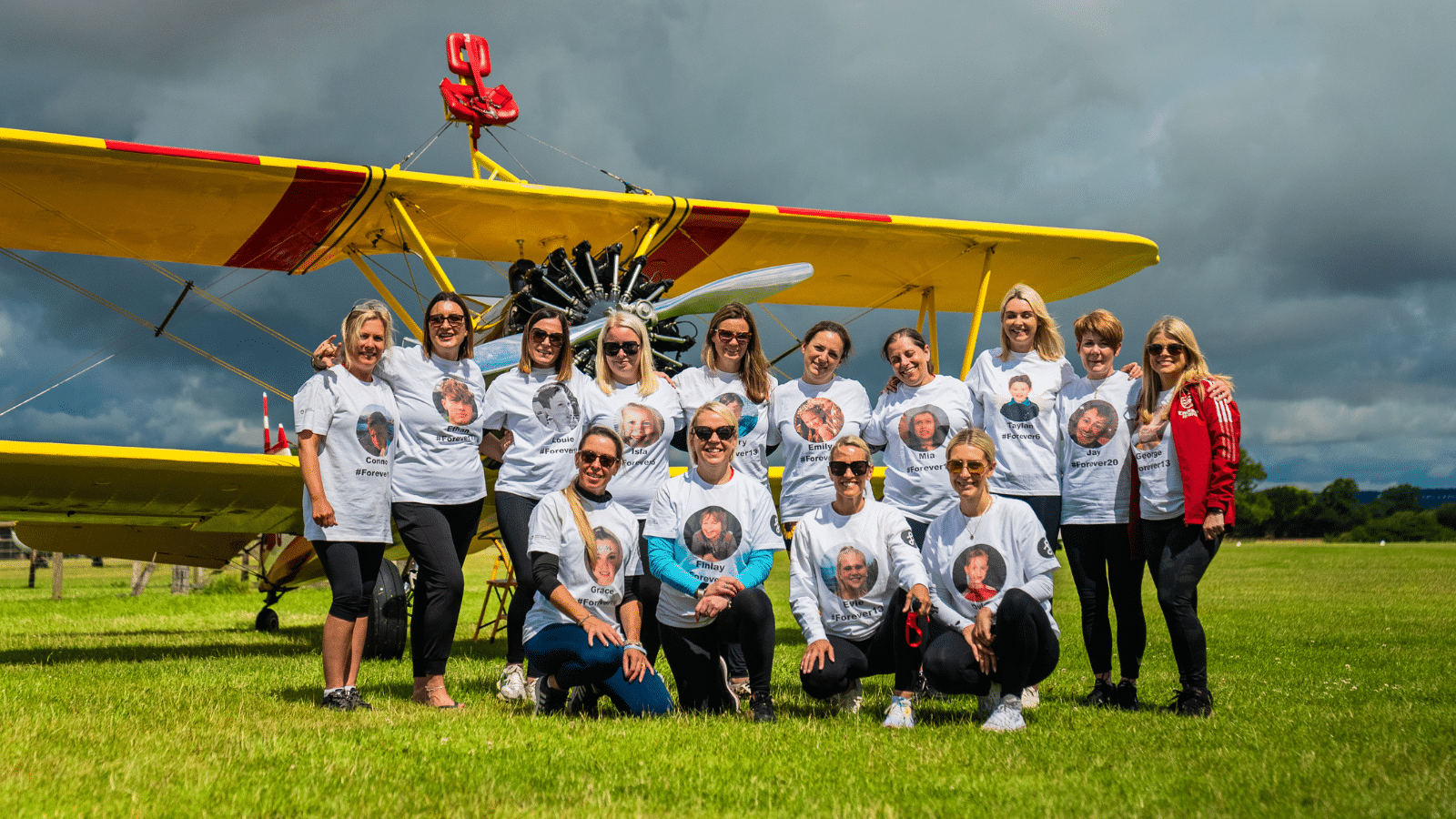 Image showing JustGiving Award winning team Angel Mums posing in front of an aeroplane.