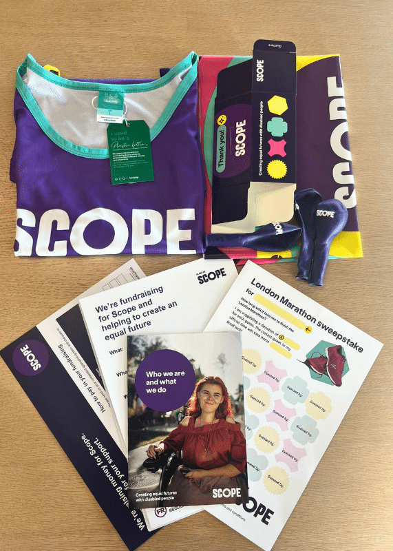 A photo of the care package items Scope sends their London Marathon fundraisers, including a running top, information about supporting the cause, balloons, and more.