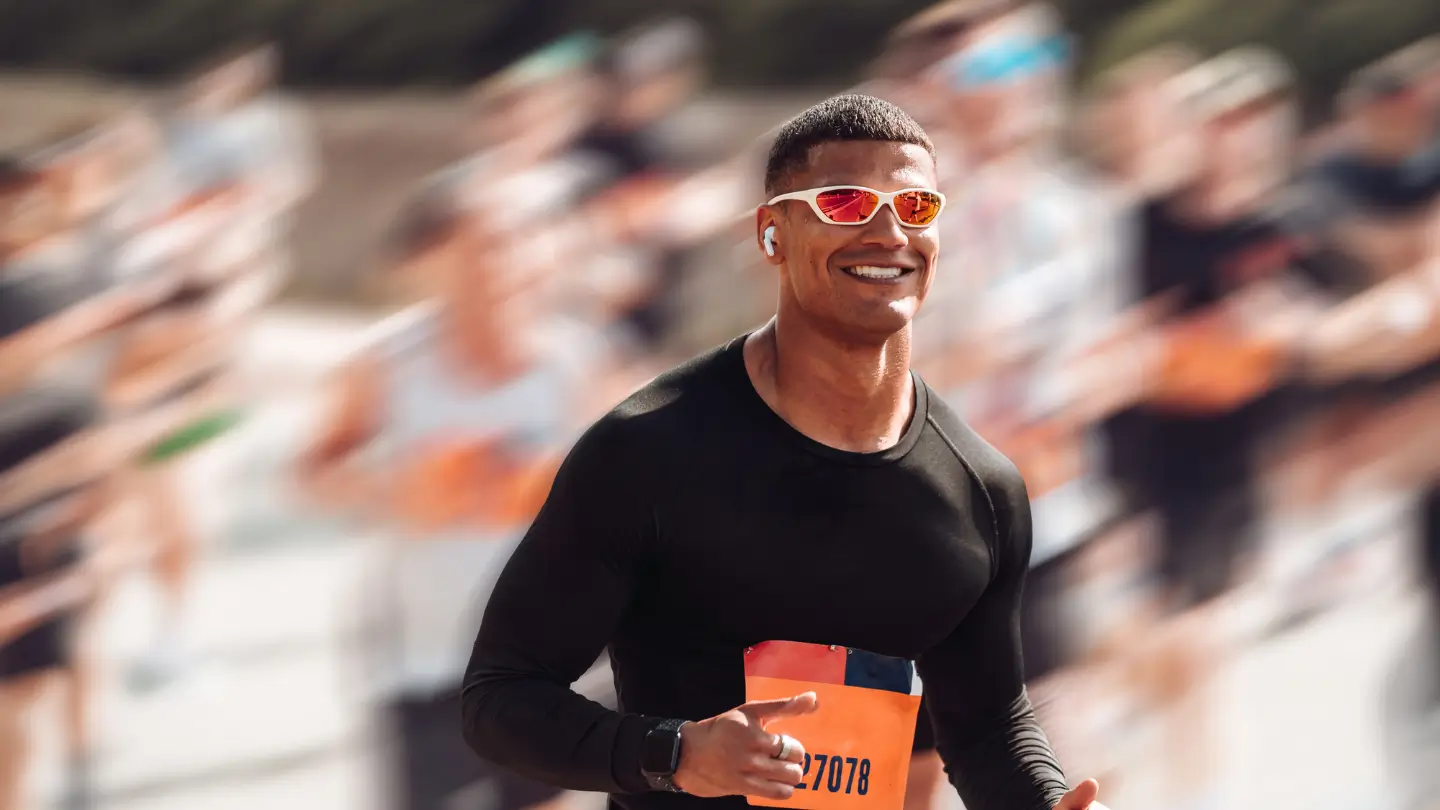 Participant with a black shirt, sunglasses, and AirPods smiling during the event